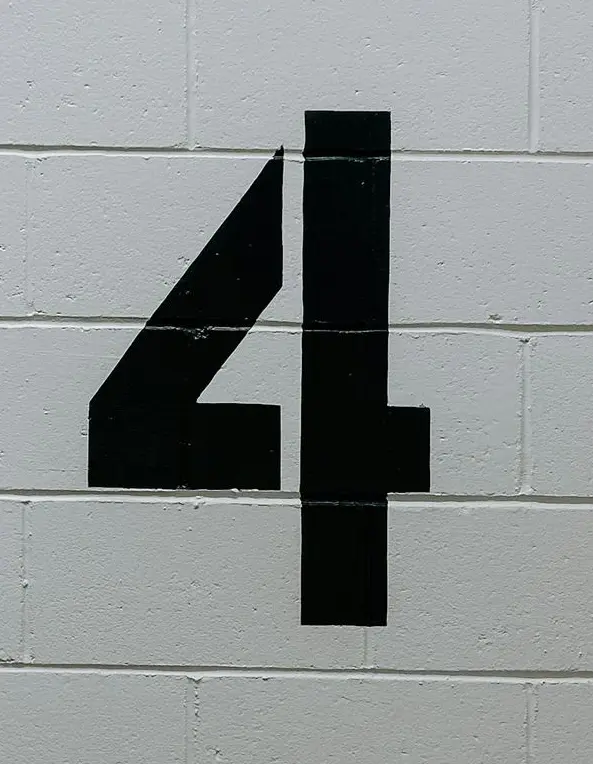 black arrow sign on white brick wall